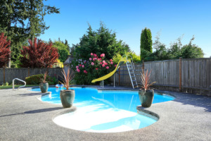 Fenced backyard with small beautiful swimming pool and playground